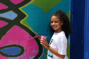 A girl painting on a wall